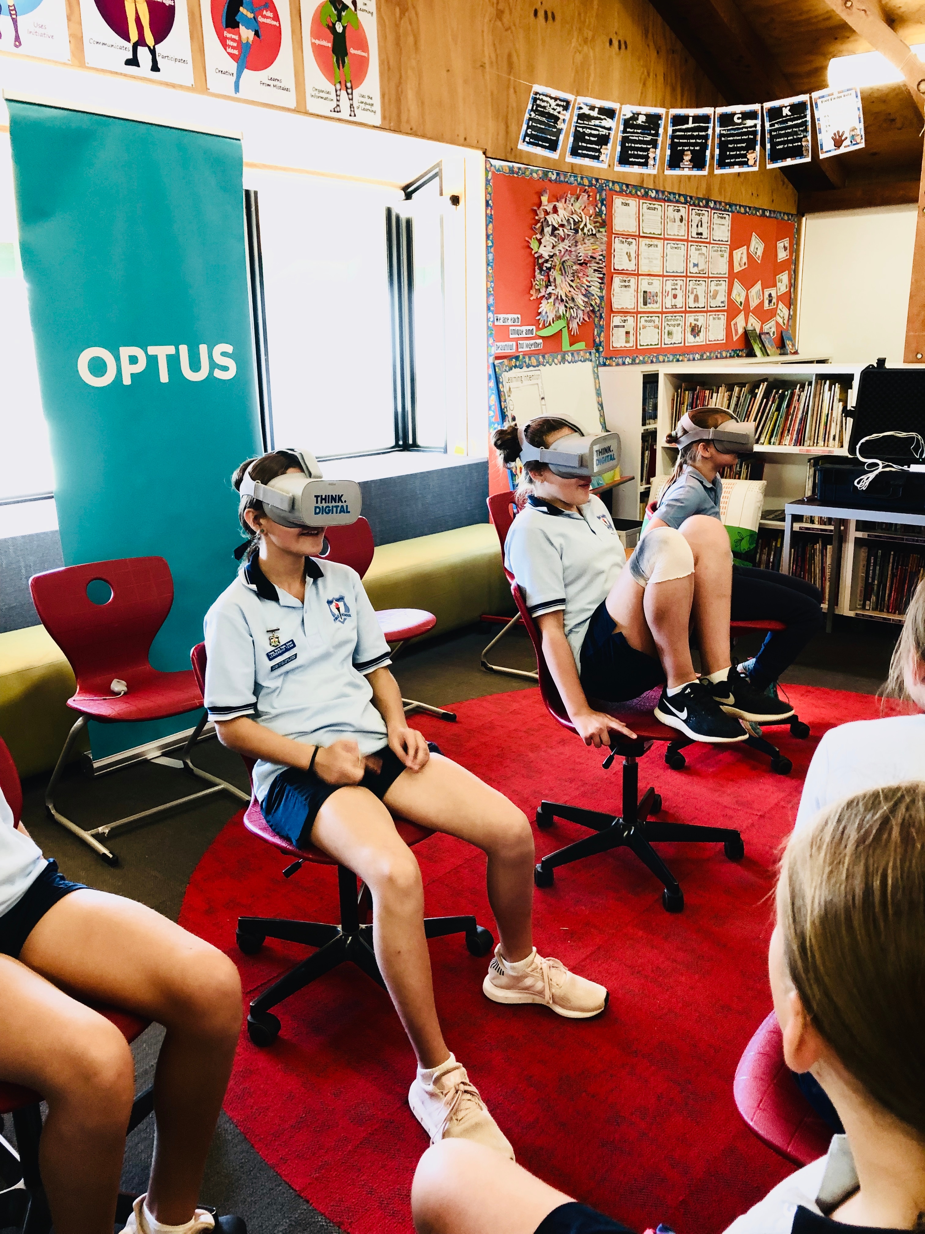 Students wearing VR goggles that have "Think Digital" printed on the front .