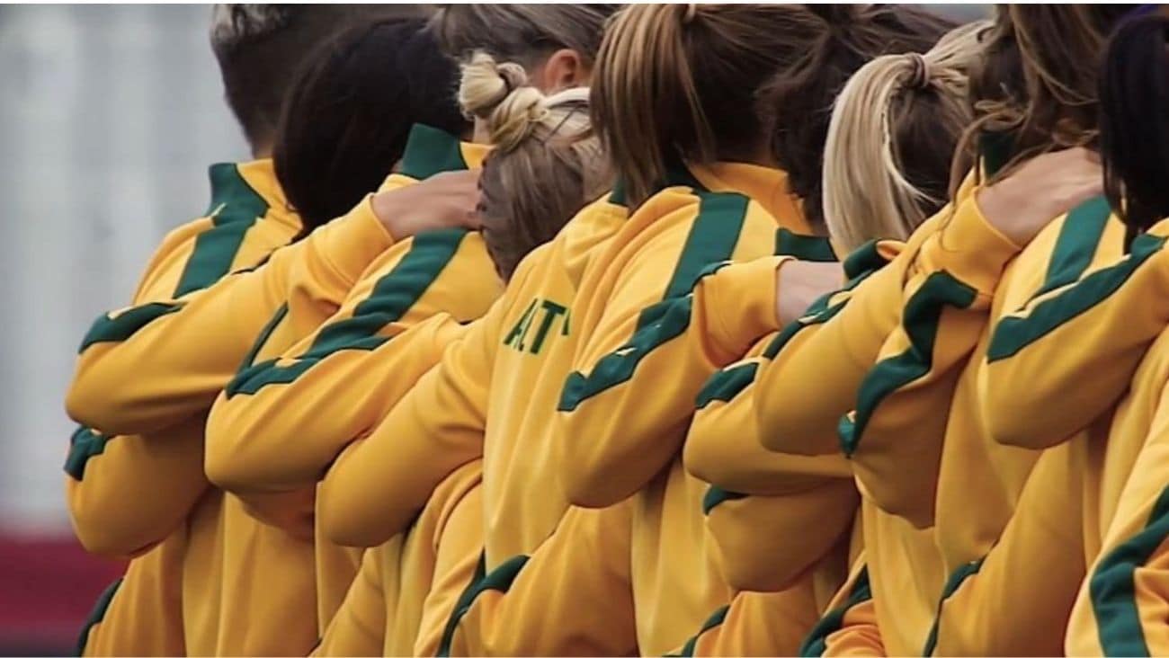 Backs of Women's World Cup Australian team arms over each others shoulders.