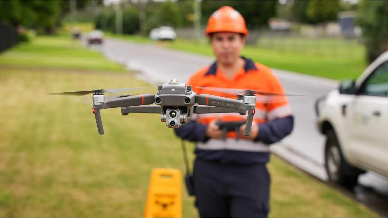 A worker controlling a drone flying in front of him with a remote