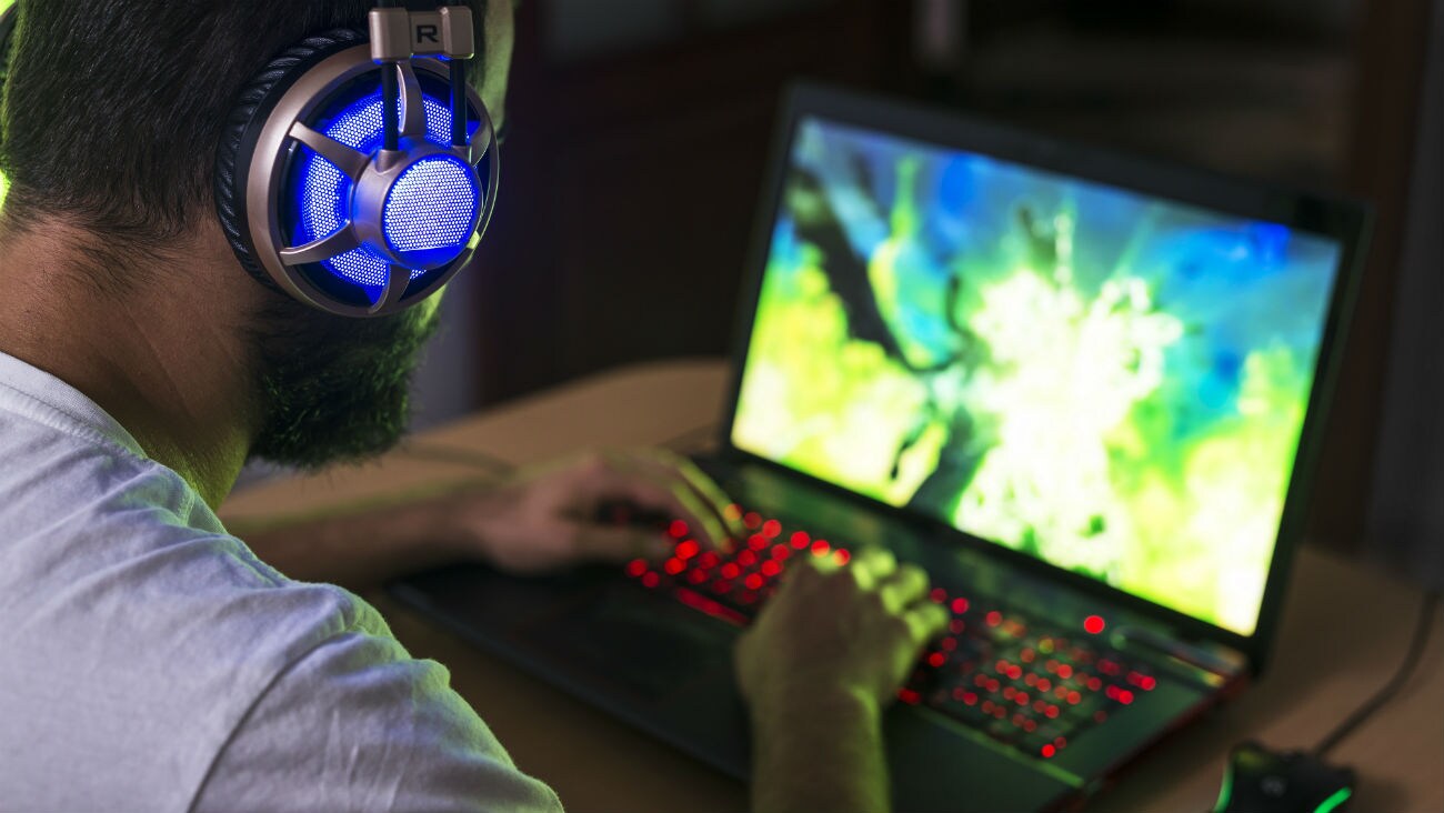 Male on computer playing comupter games with a gaming headset
