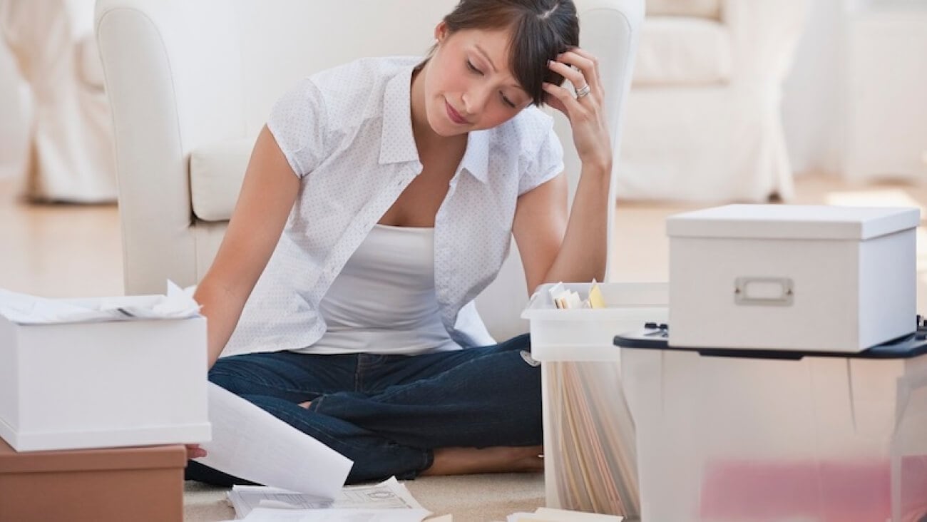 Woman at work surrounded by files who could increase collaborative working by using Google drive