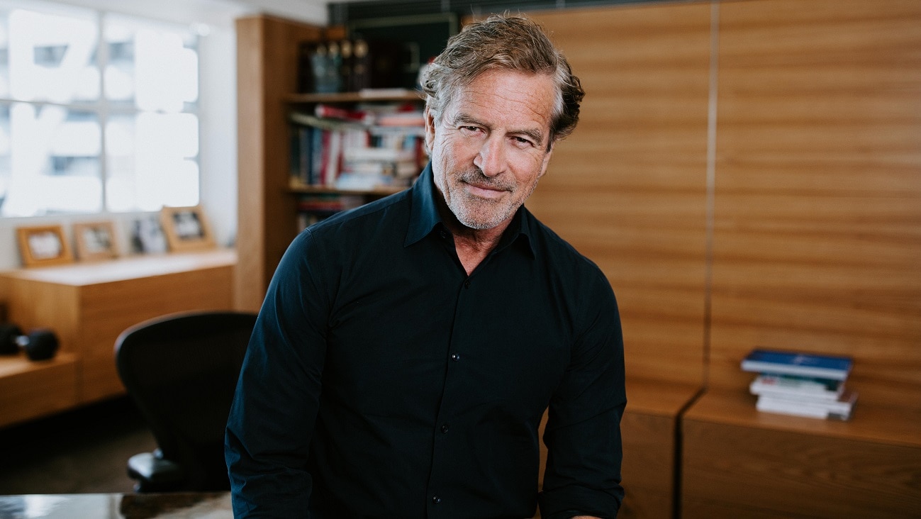 Mark Bouris wearing black shirt in an office with a window