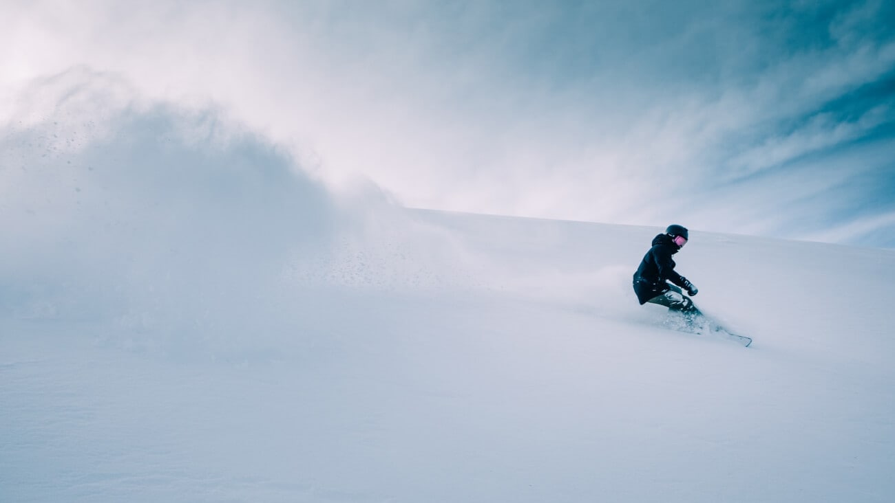 person snowboarding down a snowy hill