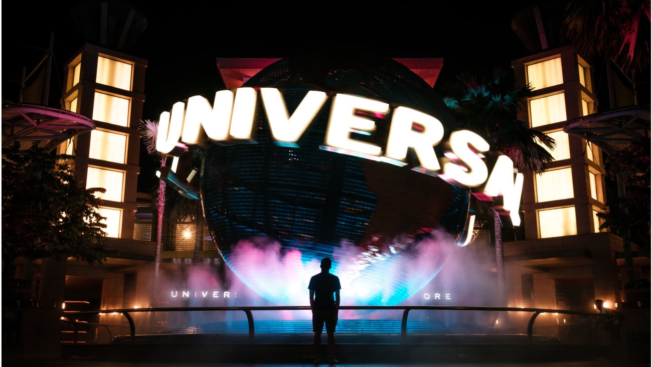 silhouette of person standing in front of huge UNIVERSAL studio logo fountain statue