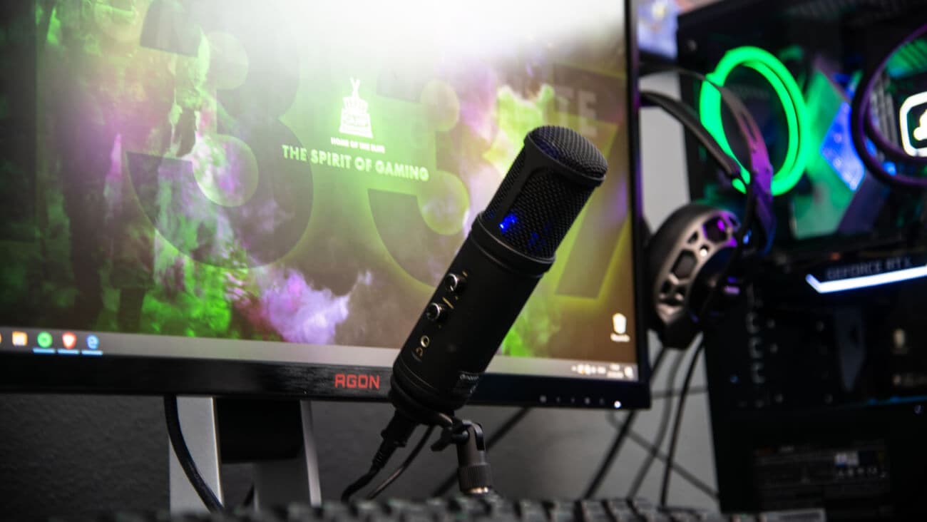 person holding game controller in-front of television