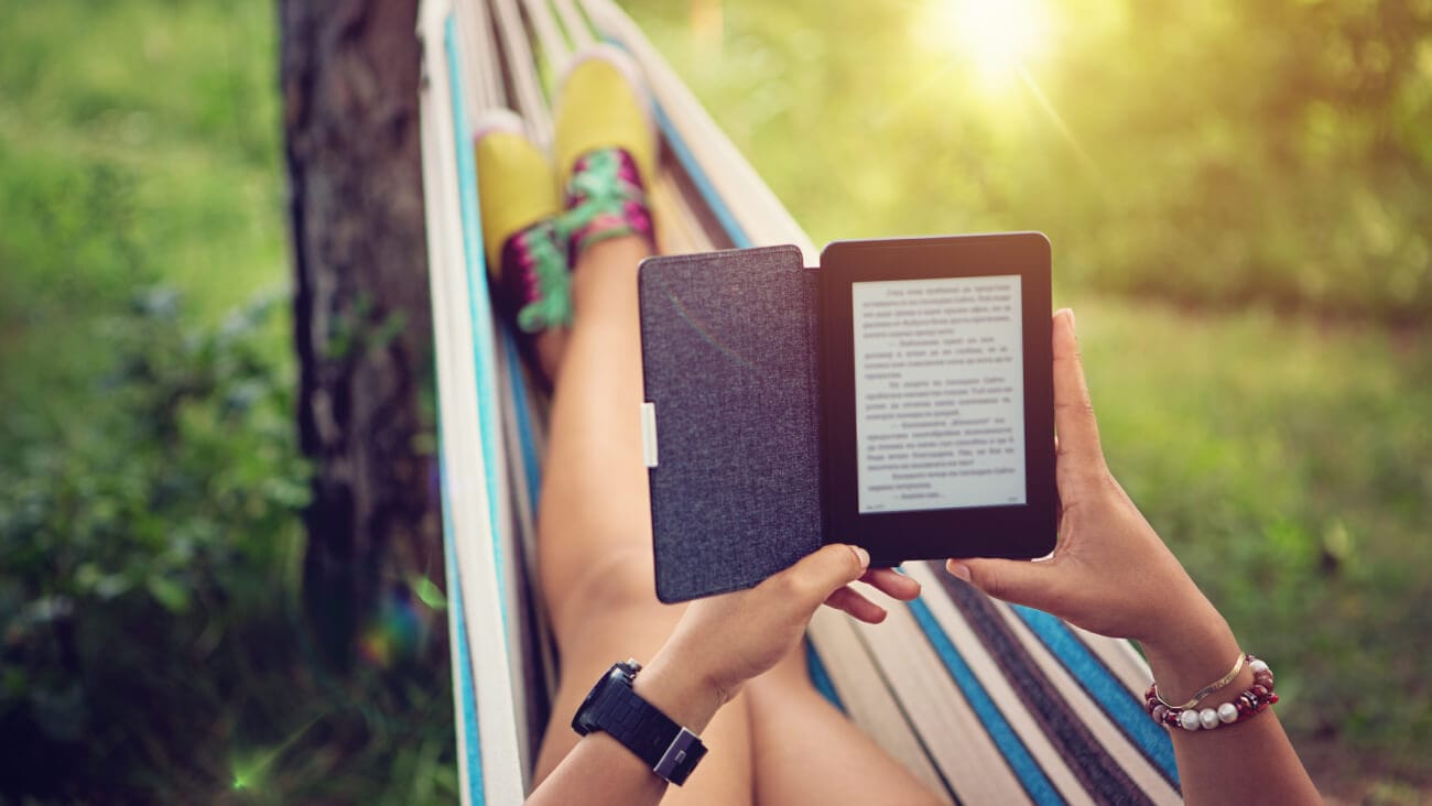person on a hammock using an eReader
