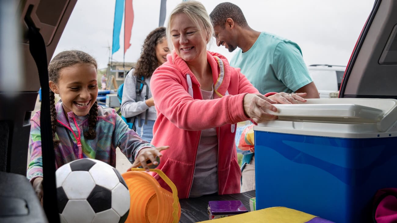 young girl football player with ball and parent