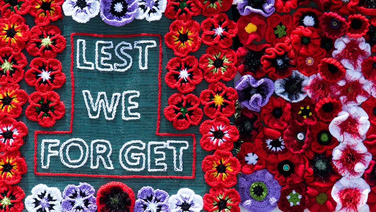 Lest we forget surrounded with embroidered red poppies