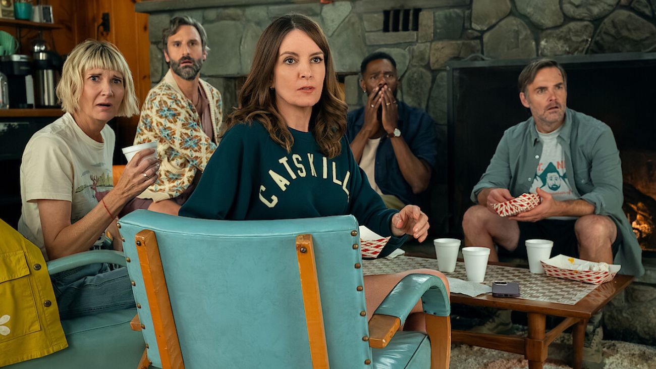 A group of people sitting at a coffee table looking shocked into the distance.