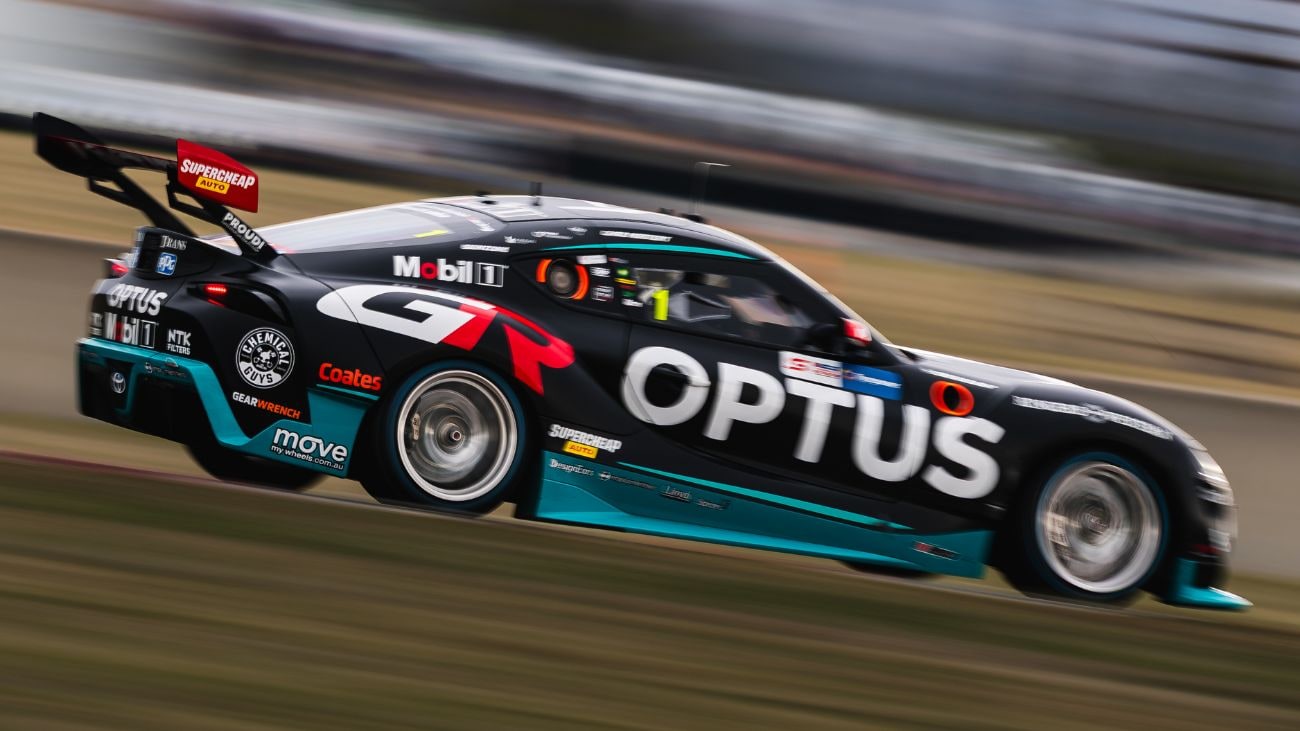 A racecar moving fast on a racetrack