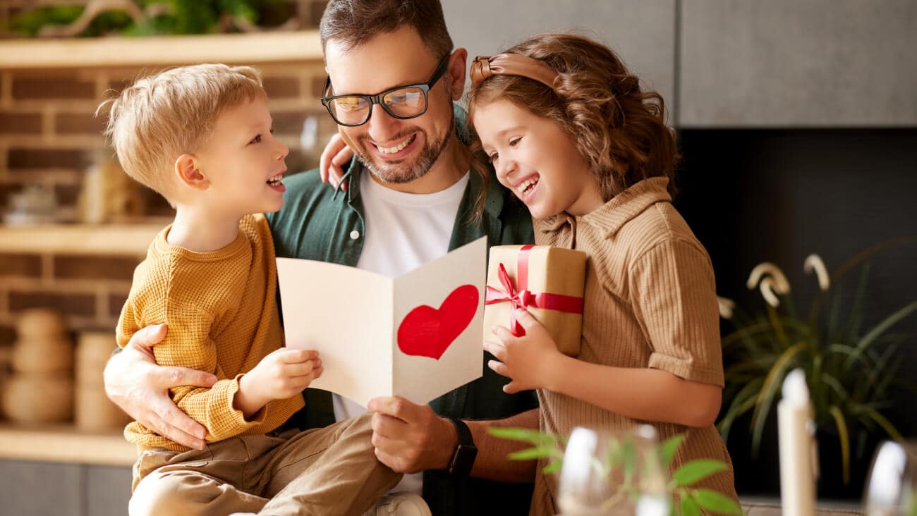 Father reading card with two kids