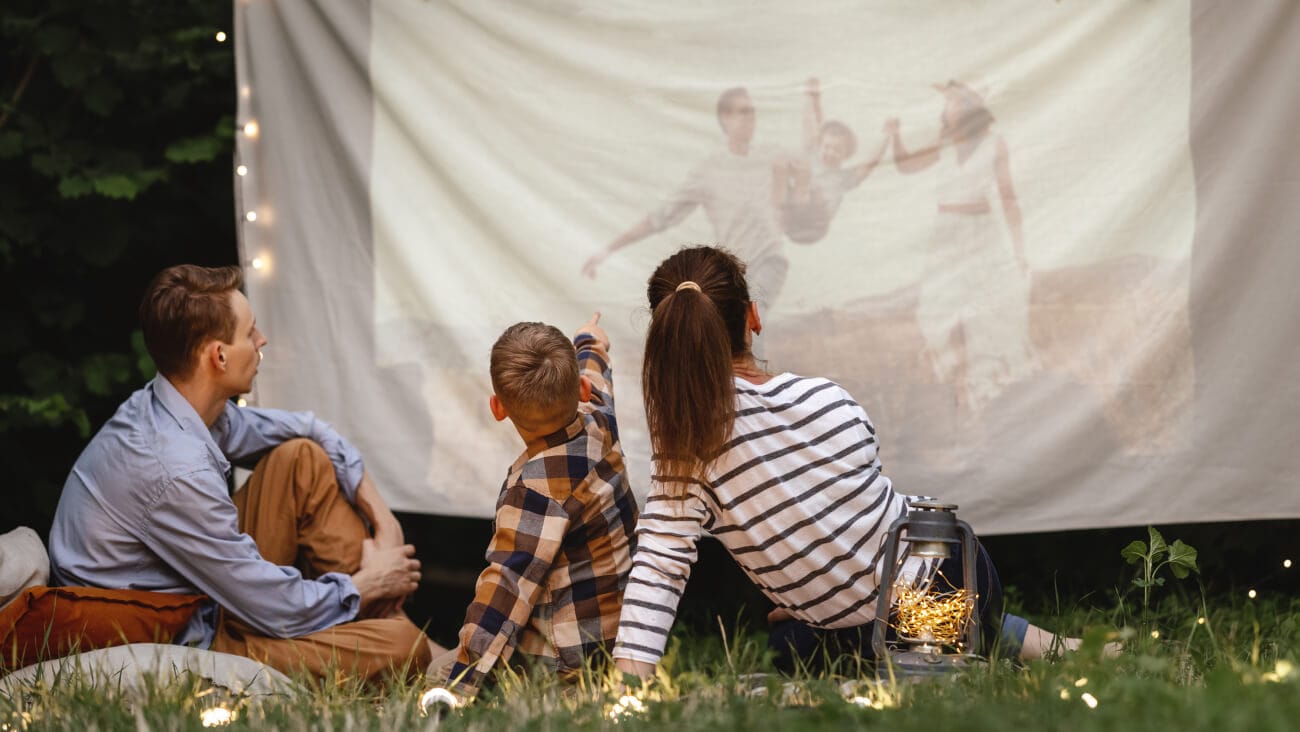 a family enjoying movie night on their backyard cinema screen