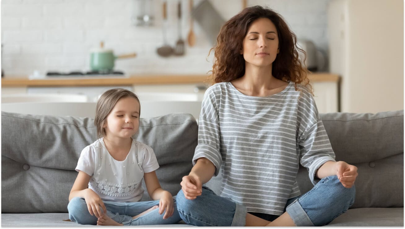 Mother and daughter meditating together
