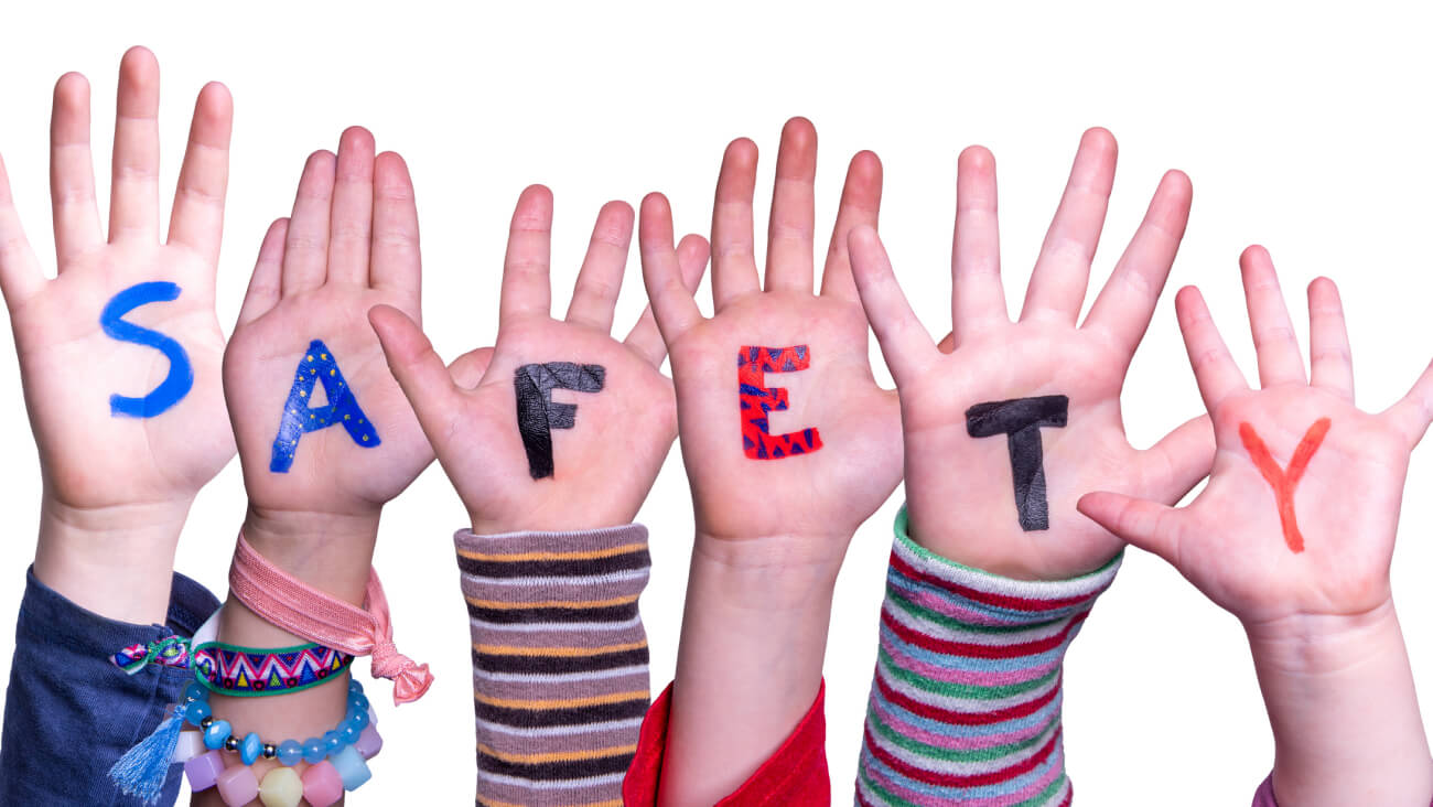The word ‘safety’ is seen spelt out on 6 children’s hands