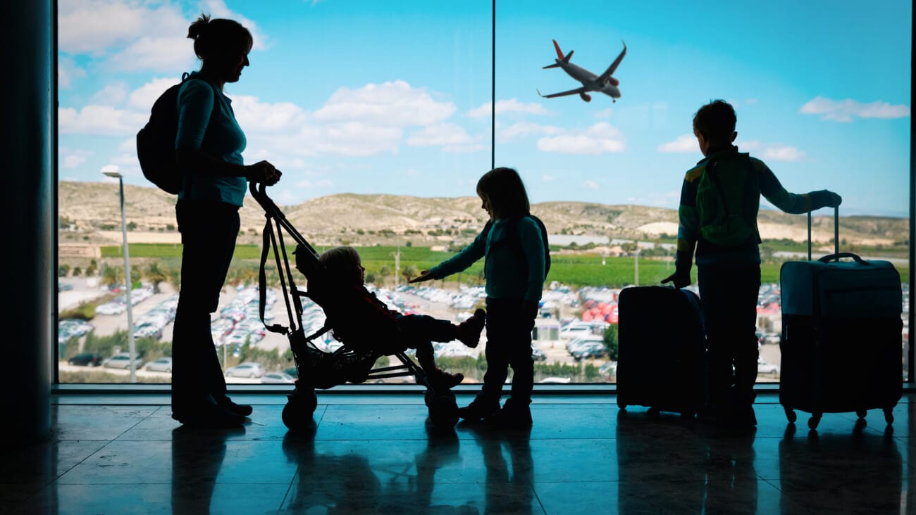 Mother at the airport with three children and suitcases