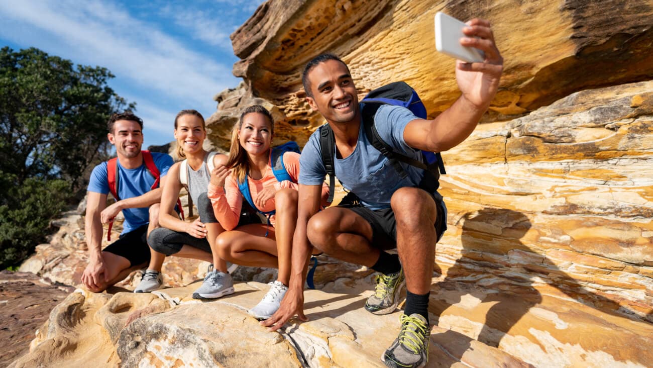 Group of young people taking a selfie while bushwalking in Australia.