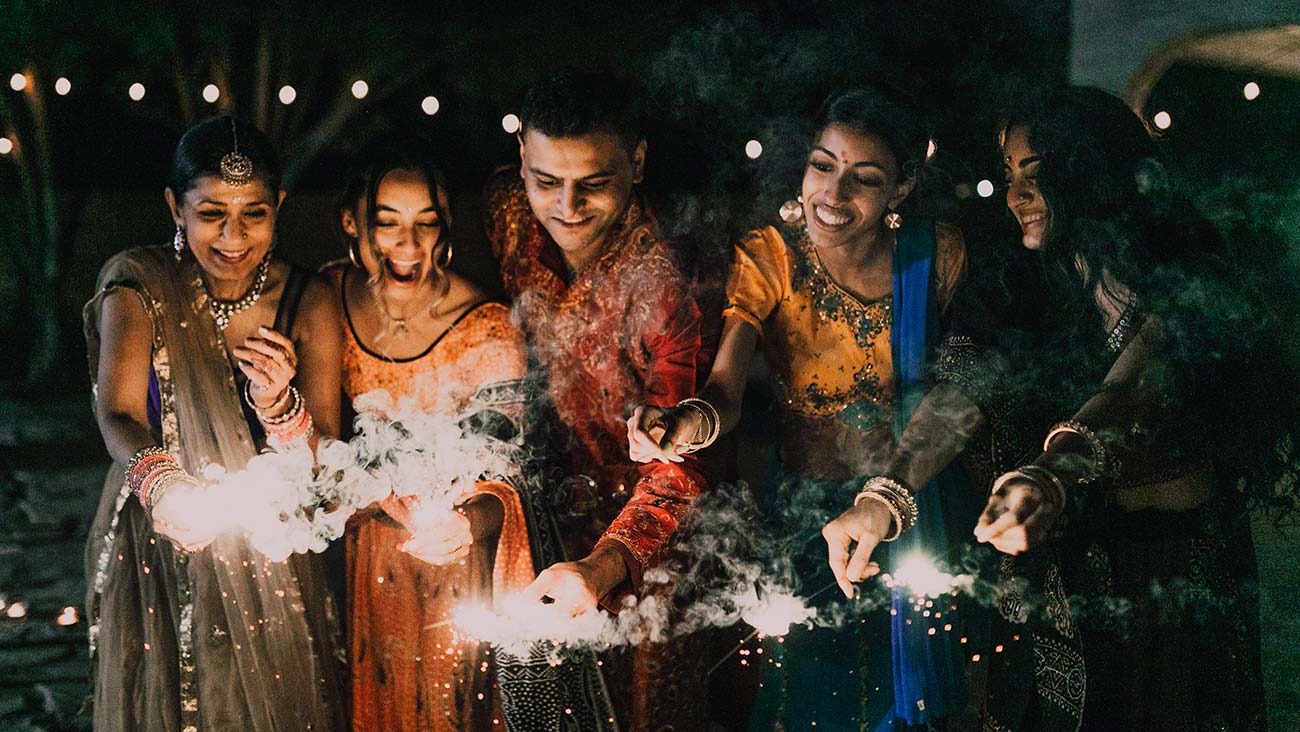 people in traditional festive Indian dress with sparklers