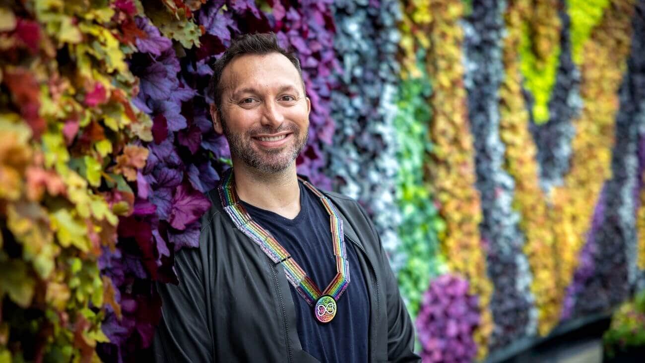 Ian Thorpe standing against a colourful background
