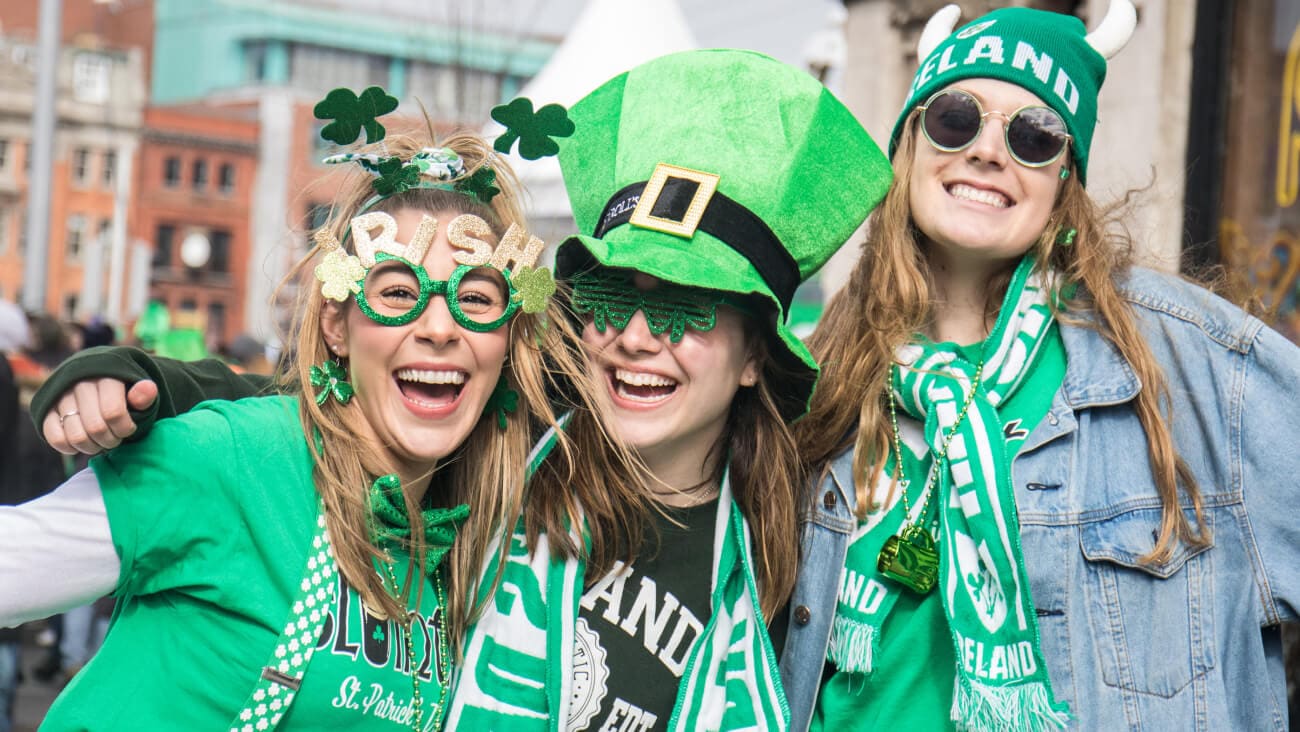 Three young smiling women all dressed up in green, celebrating St Patricks Day in Dublin, Ireland
