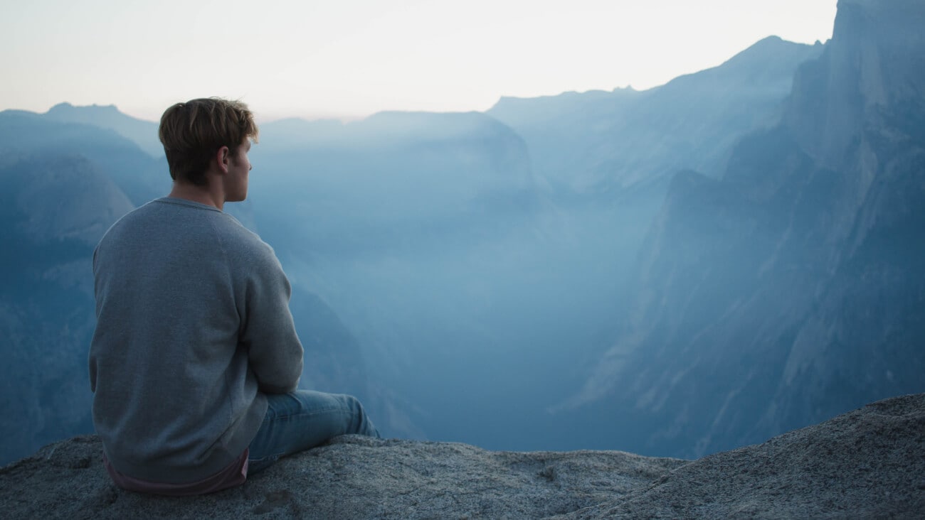 a person sitting on a mountain meditating