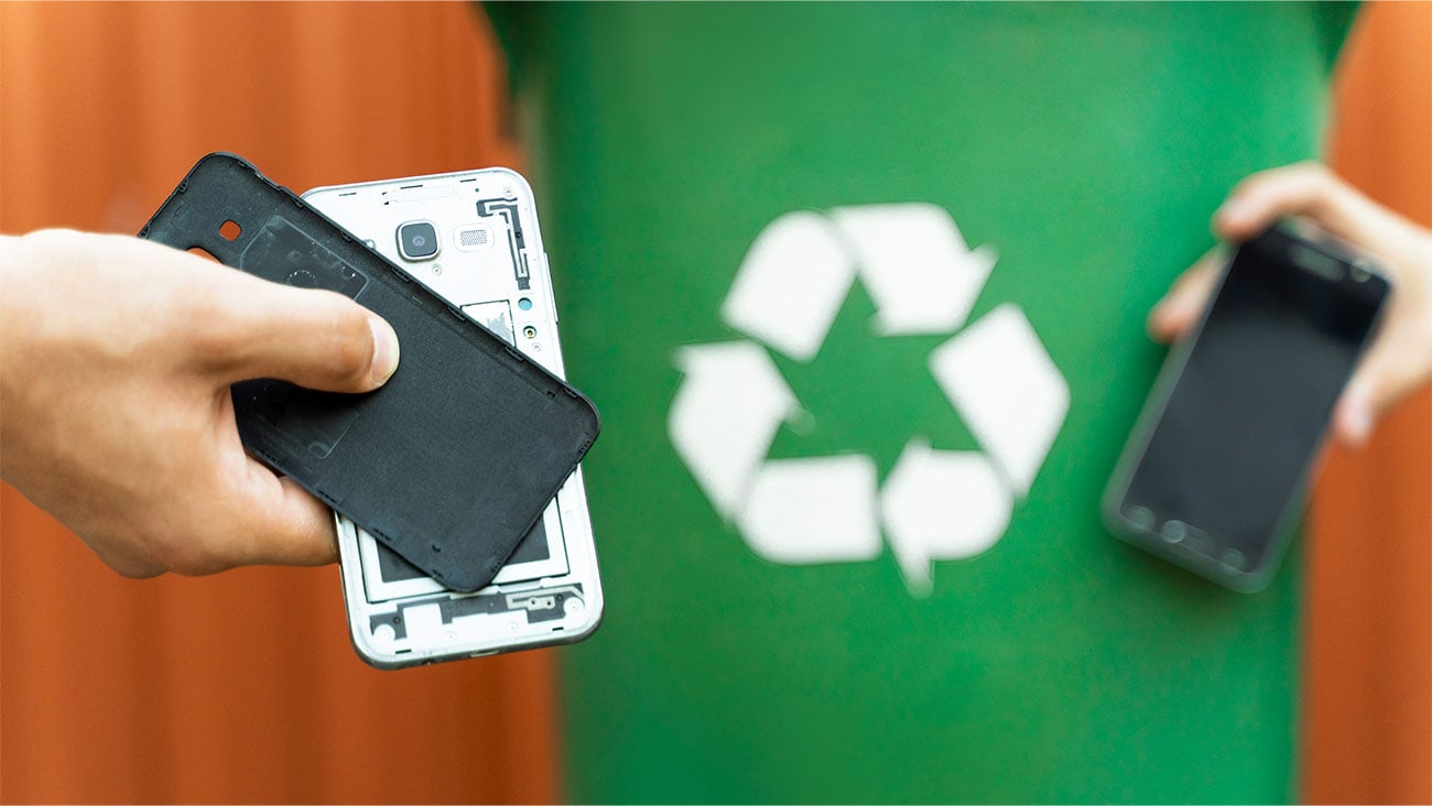 two phones against a recycling sign
