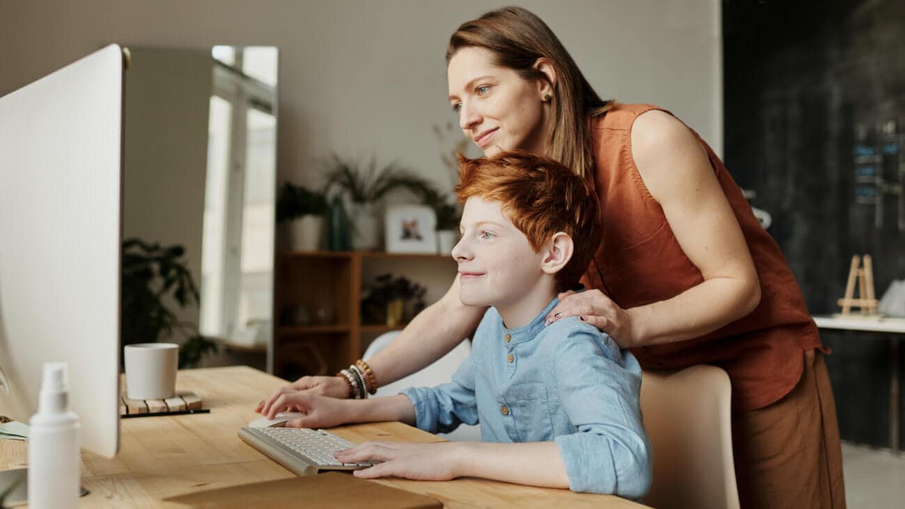 Mother helping son use the computer
