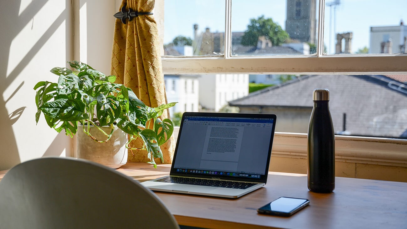 Laptop on a desk in front of a window
