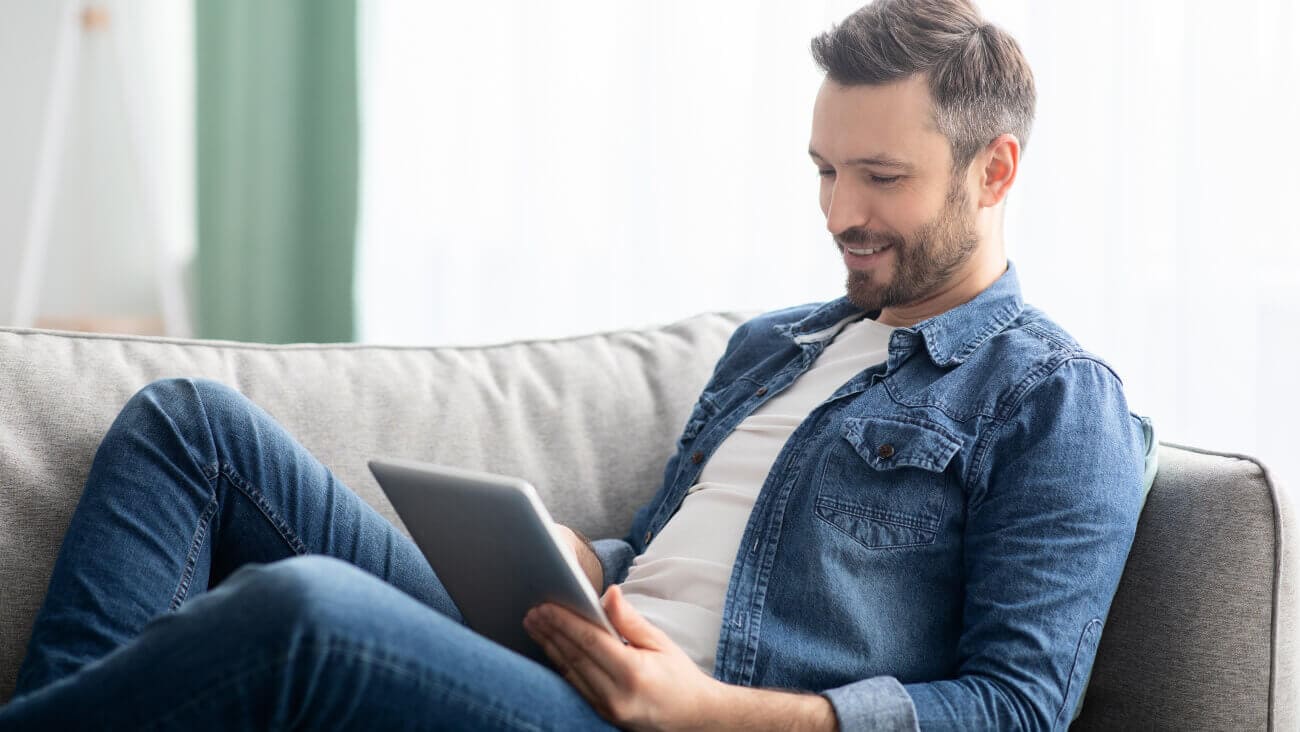 Man on a couch using a tablet