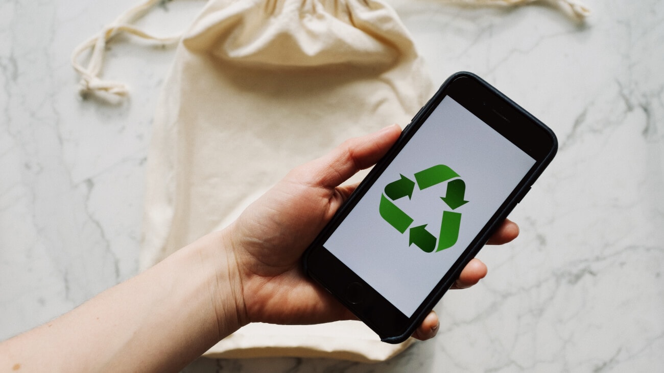 tote bag and phone with recycling symbol
