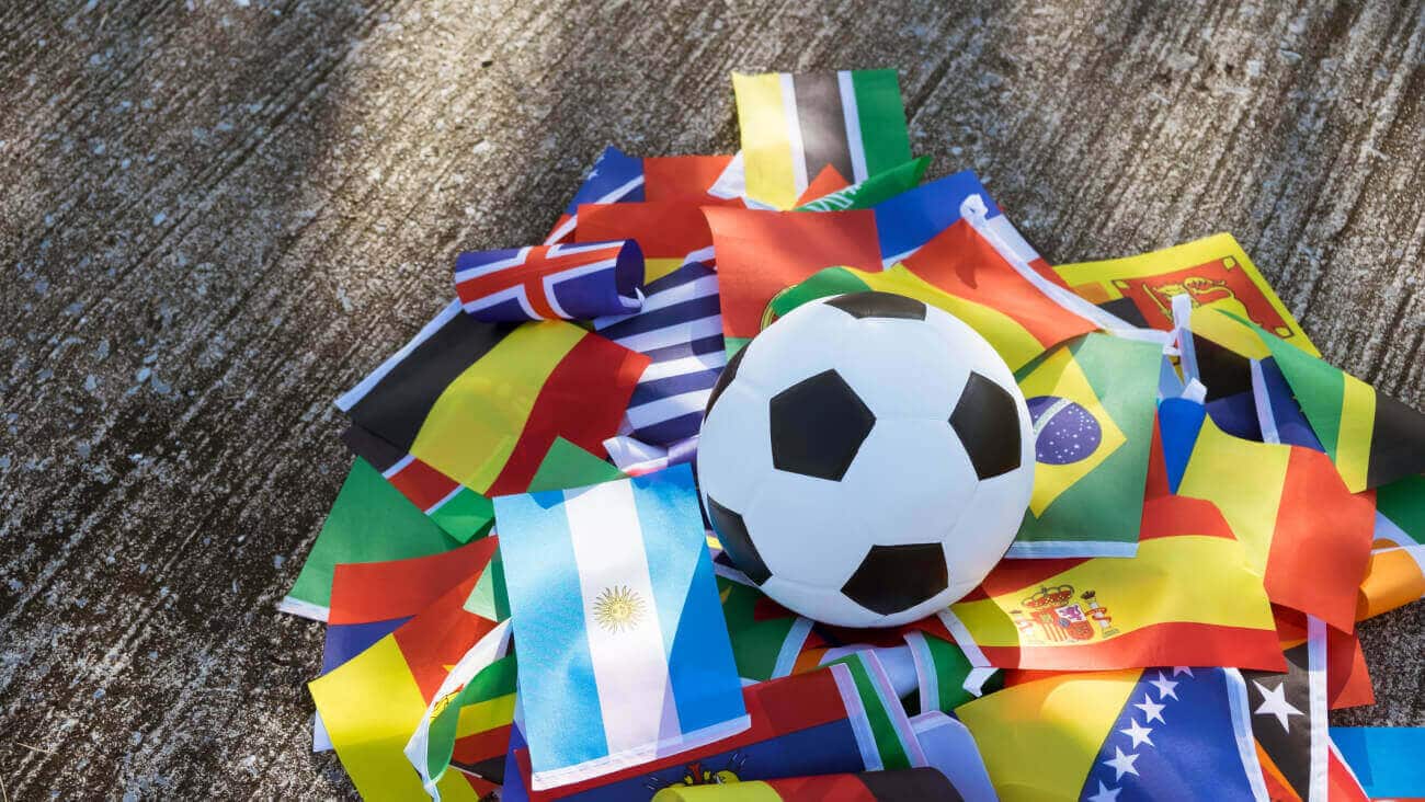Football laying on a pile of country flags