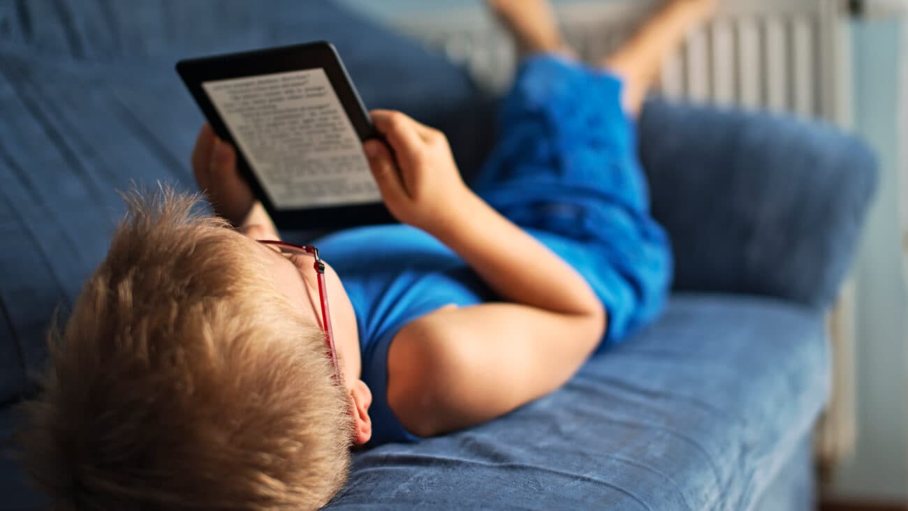 boy lying down on a couch using an eReader