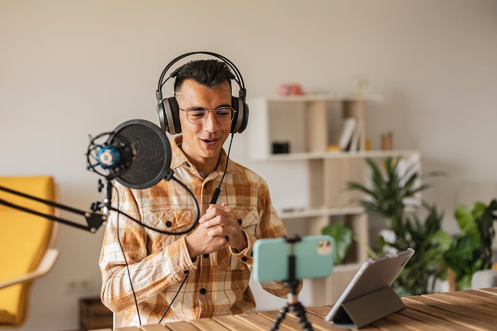 A content creator recording a podcast with seamless connectivity, highlighting the reliability of reselling Optus Wholesale NBN broadband.