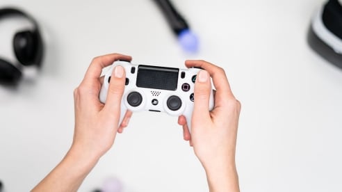 A PlayStation controller with black headphones, black and white HD camera headset and PlayStation move controllers.