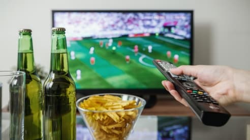 TV playing soccer and bowl of chips and drinks for a soccer game party