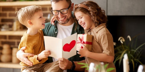 Father reading card with two kids