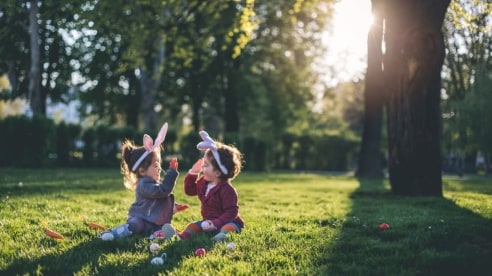Two kids playing with Easter eggs in a park