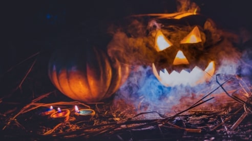 Halloween pumpkin lantern and candles with a dark background
