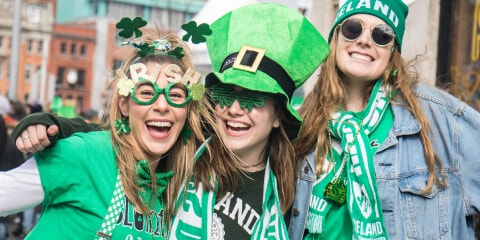 Three young smiling women all dressed up in green, celebrating St Patricks Day in Dublin, Ireland