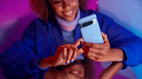 woman holding and tapping the Google Pixel 8 Pro